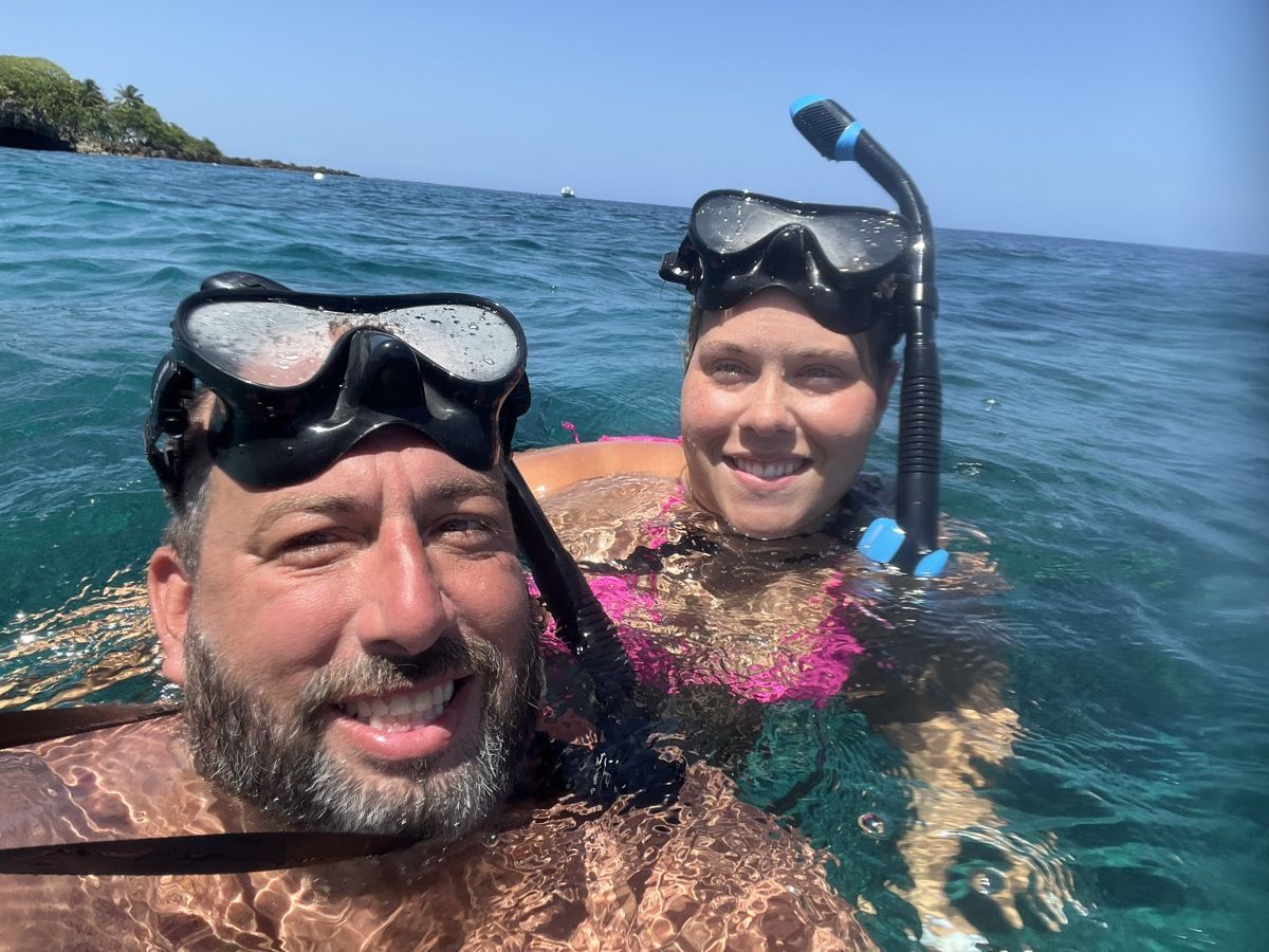 Wes Godwin and his wife in snorkel masks in clear turquoise water at West Bay Beach, Roatán